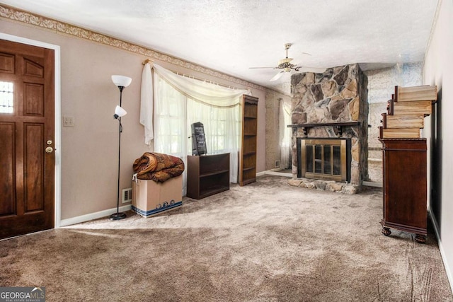 2209 Willoby Ct, Morrow, GA 30260 - unfurnished living room with carpet flooring, a stone fireplace, a ceiling fan, baseboards, and a textured ceiling