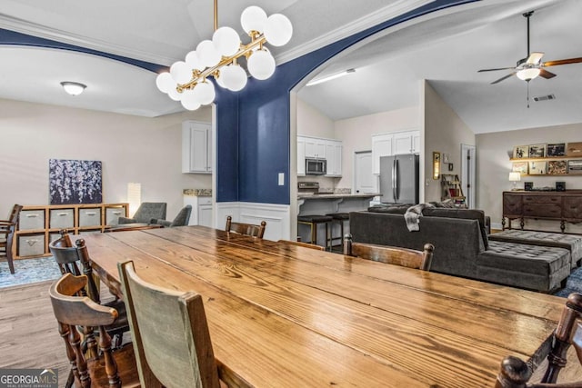 632 Holly Springs Ct, Athens, GA 30606 - dining room with ceiling fan, arched walkways, vaulted ceiling, light wood-style flooring, and crown molding