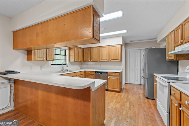 1206 Zittrouer Rd, Guyton, GA 31312 - kitchen with white electric range oven, a sink, dishwasher, a peninsula, and light wood-style flooring