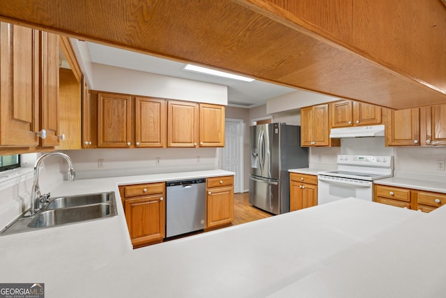 1206 Zittrouer Rd, Guyton, GA 31312 - kitchen with appliances with stainless steel finishes, under cabinet range hood, a sink, light countertops, and light wood-type flooring