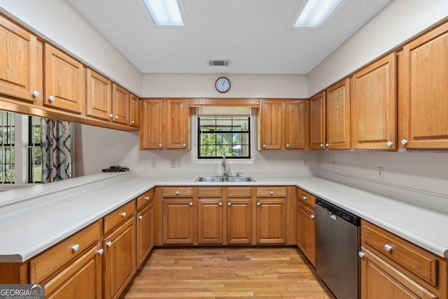 1206 Zittrouer Rd, Guyton, GA 31312 - kitchen with stainless steel dishwasher, a sink, light wood-type flooring, light countertops, and brown cabinetry
