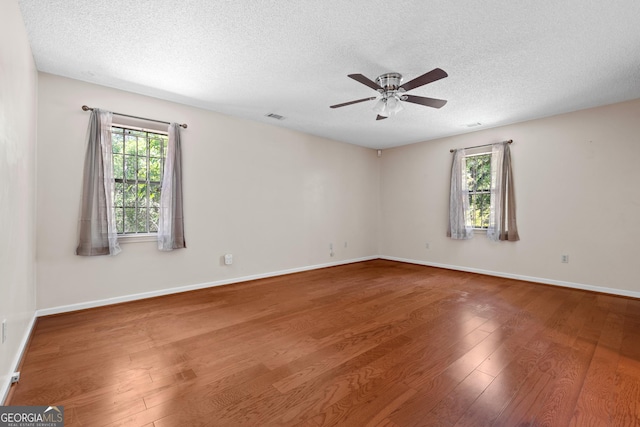 1206 Zittrouer Rd, Guyton, GA 31312 - empty room with wood finished floors, ceiling fan, plenty of natural light, a textured ceiling, and baseboards