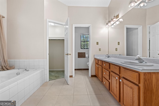 1206 Zittrouer Rd, Guyton, GA 31312 - bathroom featuring double vanity, toilet, tiled tub, and tile patterned floors
