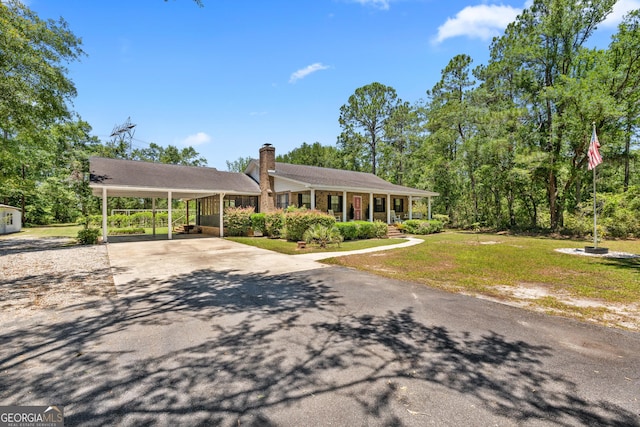 1206 Zittrouer Rd, Guyton, GA 31312 - single story home with concrete driveway, a front yard, covered porch, and a chimney