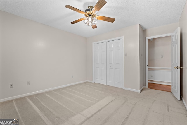 1206 Zittrouer Rd, Guyton, GA 31312 - unfurnished bedroom with light colored carpet, a closet, baseboards, a ceiling fan, and a textured ceiling