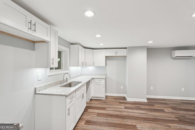 399 N Chestatee St, Dahlonega, GA 30533 - kitchen with a sink, an AC wall unit, wood finished floors, recessed lighting, and light stone counters