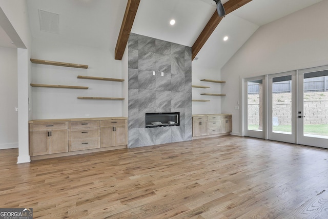 1240 Hayes Sq, Peachtree City, GA 30269 - unfurnished living room with light wood-style floors, high vaulted ceiling, a premium fireplace, beam ceiling, and french doors