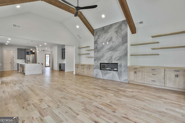 1240 Hayes Sq, Peachtree City, GA 30269 - unfurnished living room featuring high vaulted ceiling, a high end fireplace, light wood-type flooring, a ceiling fan, and beam ceiling