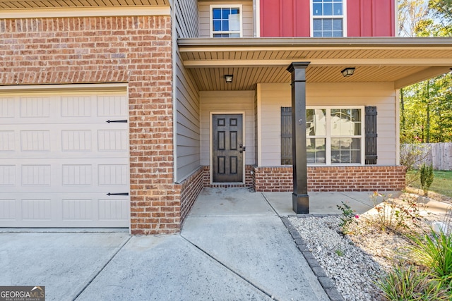475 Louise Way, Locust Grove, GA 30248 - doorway to property with brick siding, board and batten siding, covered porch, driveway, and an attached garage