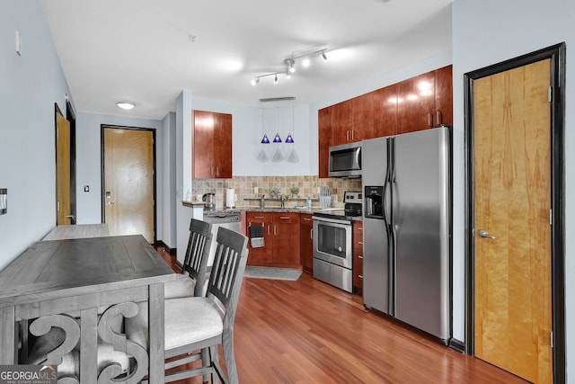 898 Oak St SW Unit 3204, Atlanta, GA 30310 - kitchen with stainless steel appliances, light wood-style flooring, backsplash, and light stone counters