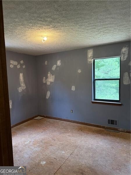 285 Woodland St, Dallas, GA 30157 - spare room with a textured ceiling and baseboards