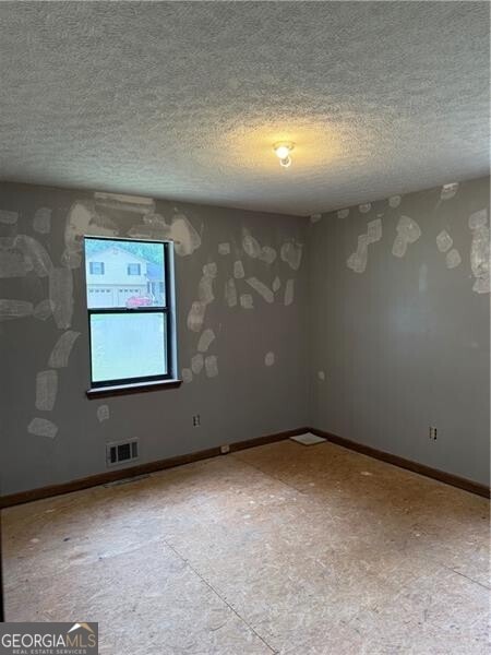 285 Woodland St, Dallas, GA 30157 - empty room featuring a textured ceiling and baseboards
