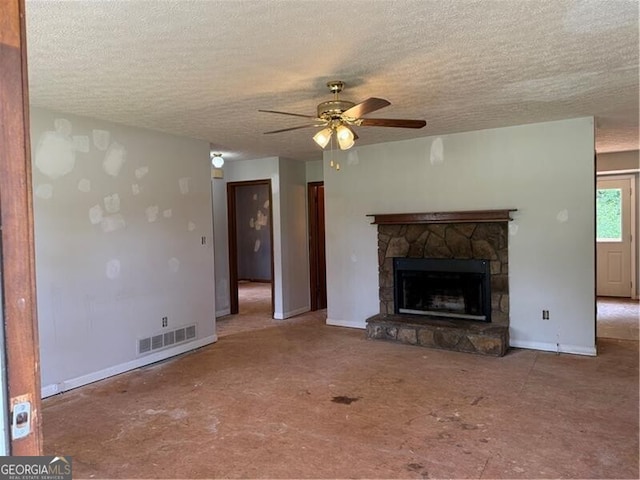 285 Woodland St, Dallas, GA 30157 - unfurnished living room featuring a ceiling fan, a textured ceiling, a stone fireplace, and baseboards