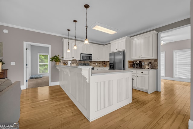 152 Charity Dr, Homer, GA 30547 - kitchen with black fridge, stainless steel microwave, a peninsula, decorative backsplash, and light wood finished floors