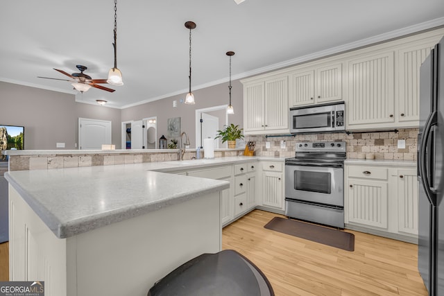152 Charity Dr, Homer, GA 30547 - kitchen featuring stainless steel appliances, a sink, a peninsula, crown molding, and tasteful backsplash