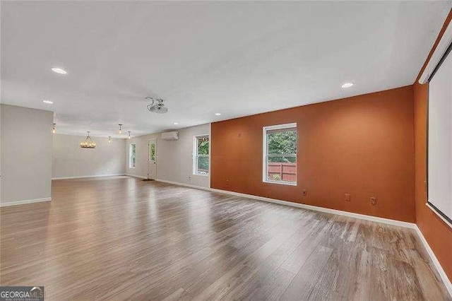 204 Starwood Ct, Acworth, GA 30102 - unfurnished room with wood finished floors, a wall mounted AC, a chandelier, baseboards, and recessed lighting