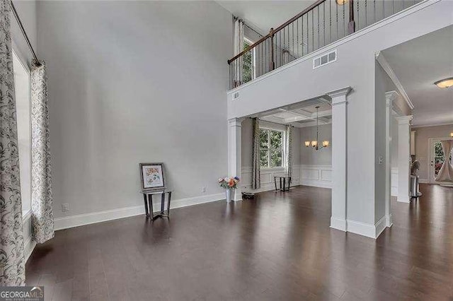 204 Starwood Ct, Acworth, GA 30102 - unfurnished living room featuring wood finished floors, decorative columns, crown molding, a chandelier, and a high ceiling