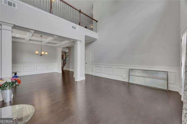 204 Starwood Ct, Acworth, GA 30102 - unfurnished living room with ornate columns, a chandelier, a decorative wall, wood finished floors, and coffered ceiling