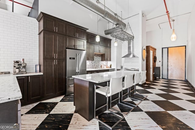 87 Peachtree St SW Unit 209, Atlanta, GA 30303 - kitchen with high end fridge, a towering ceiling, wall chimney exhaust hood, tasteful backsplash, and dark brown cabinets