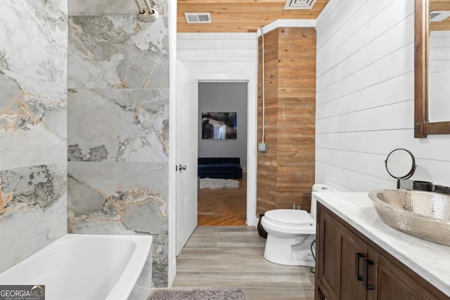 87 Peachtree St SW Unit 209, Atlanta, GA 30303 - full bath featuring a tub, wood walls, vanity, toilet, and wood finished floors
