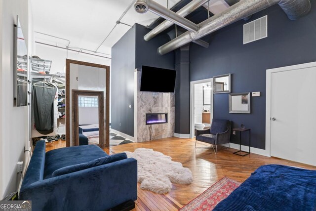 87 Peachtree St SW Unit 209, Atlanta, GA 30303 - living area with a premium fireplace, hardwood / wood-style flooring, a towering ceiling, and baseboards