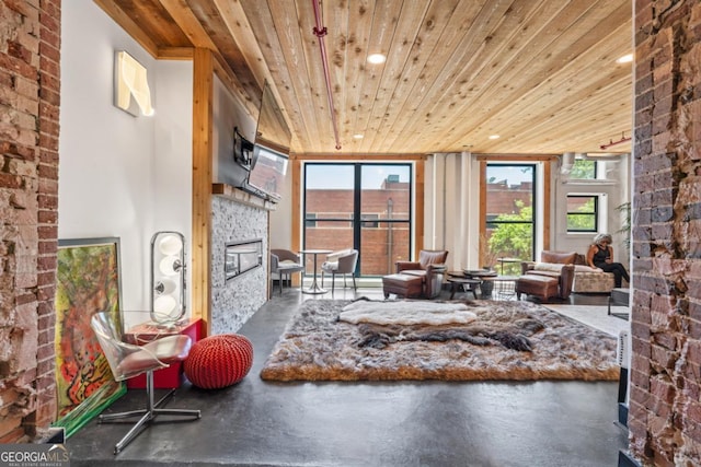 87 Peachtree St SW Unit 209, Atlanta, GA 30303 - sitting room with wood ceiling, a glass covered fireplace, finished concrete flooring, and recessed lighting