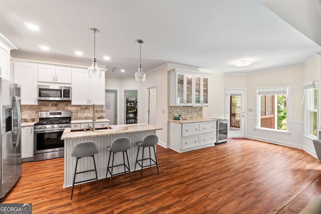 635 Piping Rock Pt, Lawrenceville, GA 30043 - kitchen featuring appliances with stainless steel finishes, wine cooler, decorative backsplash, a breakfast bar, and white cabinetry