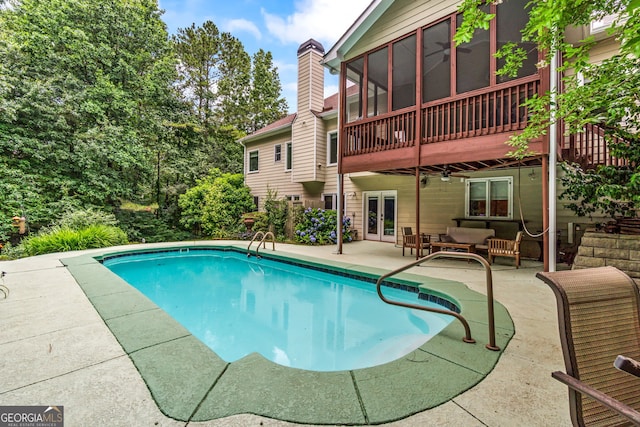 635 Piping Rock Pt, Lawrenceville, GA 30043 - swimming pool with french doors, a patio, a sunroom, and an outdoor living space