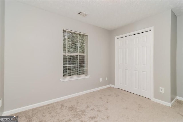 5229 Kirk Dr, Atlanta, GA 30349 - unfurnished bedroom featuring carpet, baseboards, a closet, and a textured ceiling