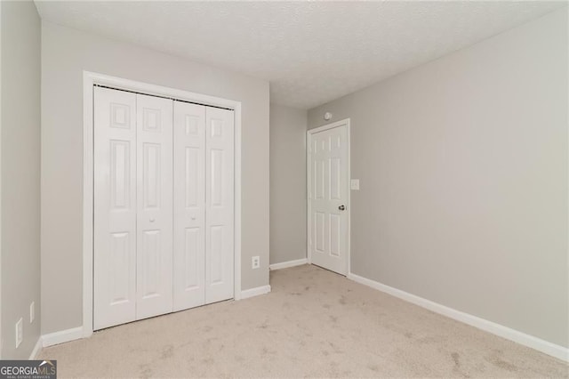 5229 Kirk Dr, Atlanta, GA 30349 - unfurnished bedroom featuring light carpet, a closet, baseboards, and a textured ceiling