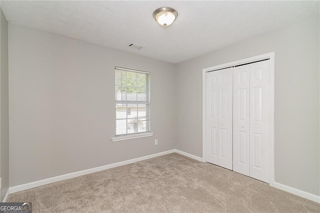 5229 Kirk Dr, Atlanta, GA 30349 - unfurnished bedroom featuring carpet, a closet, baseboards, and a textured ceiling