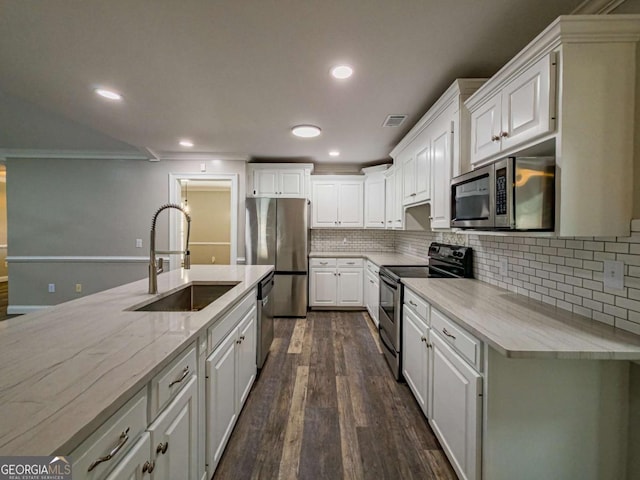 34 Alan Ln Unit 7, Tifton, GA 31793 - kitchen with appliances with stainless steel finishes, a sink, dark wood-style flooring, white cabinets, and decorative backsplash