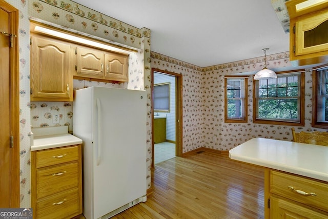 156 Spoon Hill Dr, Hayesville, NC 28904 - kitchen with freestanding refrigerator, wallpapered walls, light wood finished floors, light countertops, and baseboards