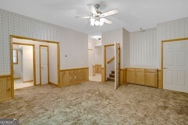 156 Spoon Hill Dr, Hayesville, NC 28904 - unfurnished bedroom with wainscoting, wallpapered walls, light carpet, a ceiling fan, and wooden walls