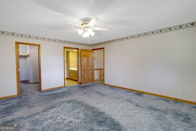 156 Spoon Hill Dr, Hayesville, NC 28904 - unfurnished bedroom with a spacious closet, baseboards, carpet floors, connected bathroom, and a ceiling fan