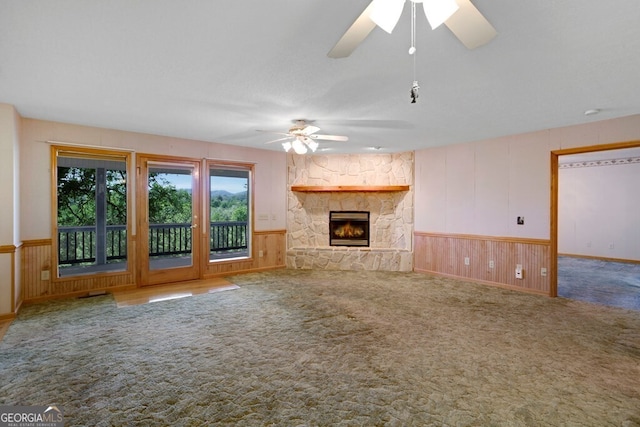 156 Spoon Hill Dr, Hayesville, NC 28904 - unfurnished living room with ceiling fan, carpet flooring, a fireplace, a wainscoted wall, and wood walls