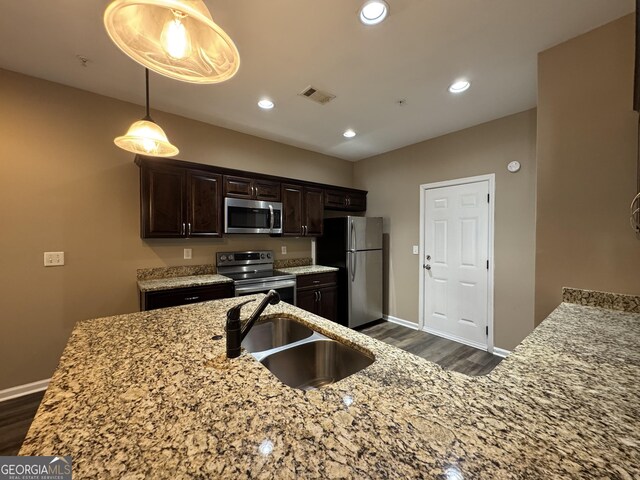 1853 Broad River Rd, Atlanta, GA 30349 - kitchen featuring stainless steel appliances, a sink, dark wood-style flooring, dark brown cabinetry, and recessed lighting