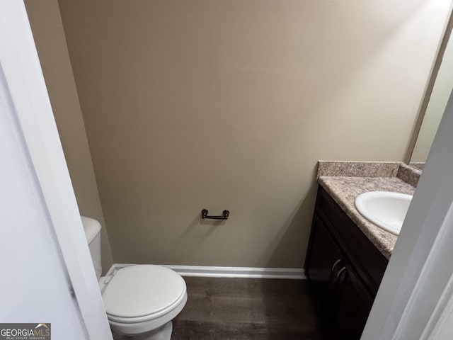 1853 Broad River Rd, Atlanta, GA 30349 - bathroom featuring vanity, toilet, wood finished floors, and baseboards