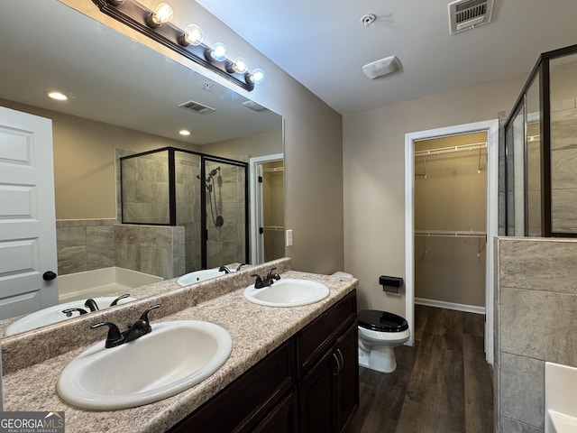 1853 Broad River Rd, Atlanta, GA 30349 - full bath featuring wood finished floors, a stall shower, toilet, a bath, and double vanity