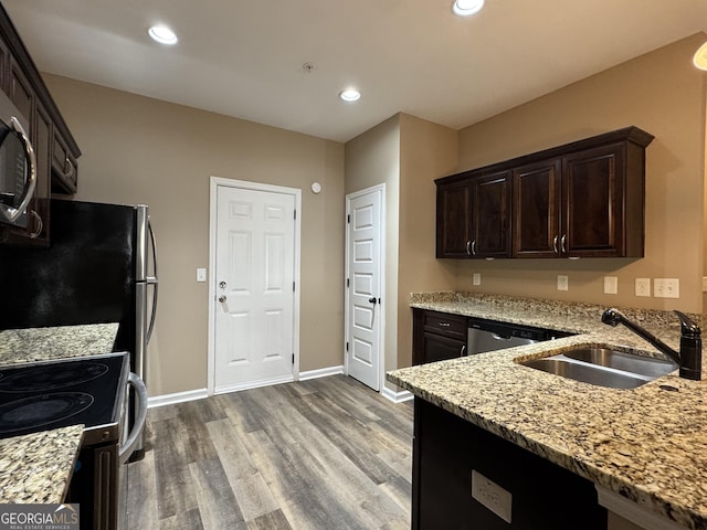1853 Broad River Rd, Atlanta, GA 30349 - kitchen with a sink, wood finished floors, light stone countertops, dark brown cabinets, and recessed lighting
