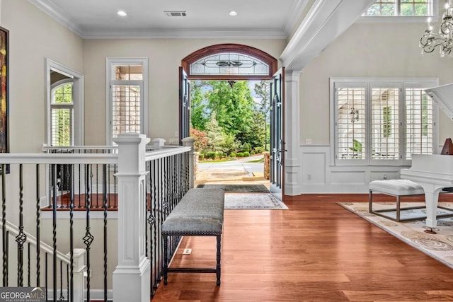 1461 N Shore Dr, Greensboro, GA 30642 - foyer with healthy amount of natural light, wood finished floors, a chandelier, ornamental molding, and a wainscoted wall