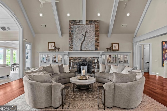 1461 N Shore Dr, Greensboro, GA 30642 - living area featuring high vaulted ceiling, beamed ceiling, wood finished floors, a stone fireplace, and recessed lighting
