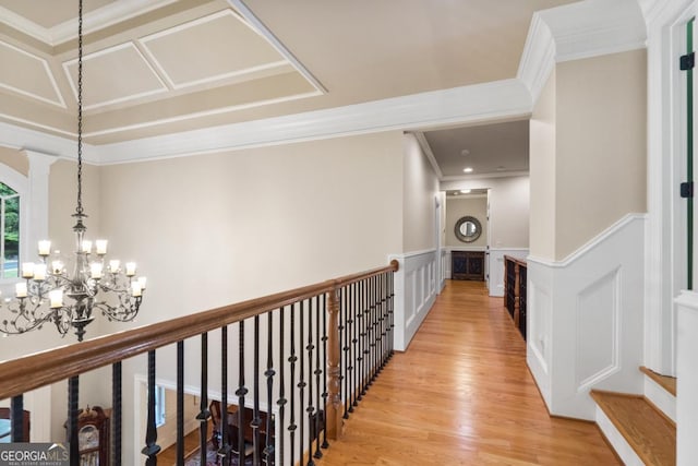 13037 Overlook Pass, Roswell, GA 30075 - hallway with wainscoting, light wood-type flooring, crown molding, a decorative wall, and a chandelier