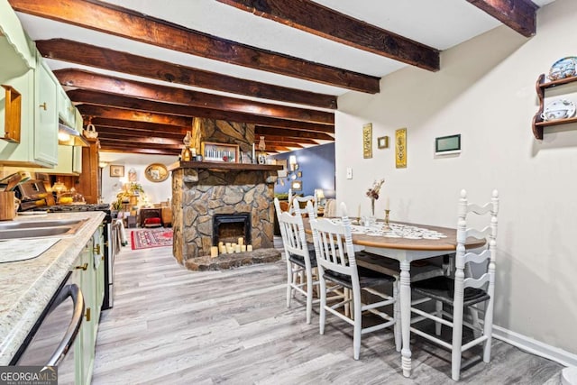 251 Lang St, Griffin, GA 30223 - dining room with light wood-type flooring, beamed ceiling, and a stone fireplace