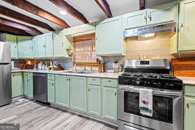 251 Lang St, Griffin, GA 30223 - kitchen with appliances with stainless steel finishes, green cabinetry, under cabinet range hood, a sink, and beamed ceiling