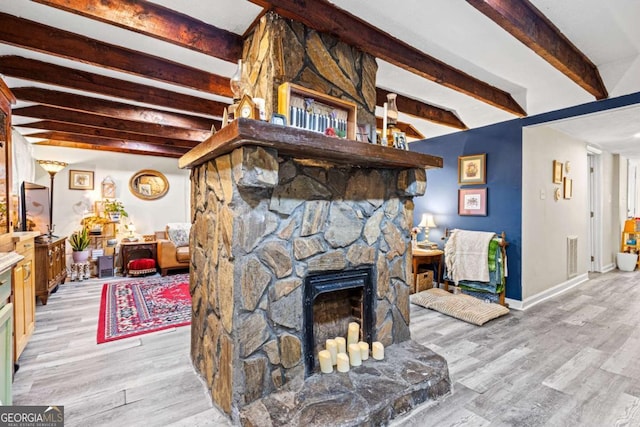 251 Lang St, Griffin, GA 30223 - living room featuring beamed ceiling, light wood-style flooring, a fireplace, and baseboards