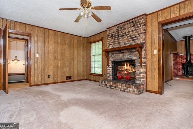 3549 Dogwood Dr, Powder Springs, GA 30127 - unfurnished living room featuring wood walls, a wood stove, carpet flooring, ceiling fan, and a textured ceiling