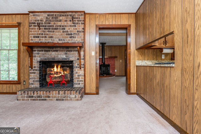 3549 Dogwood Dr, Powder Springs, GA 30127 - unfurnished living room with wooden walls, a wood stove, carpet flooring, baseboards, and crown molding