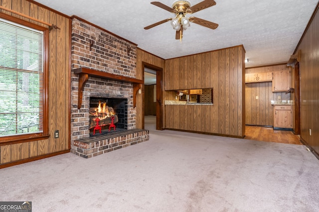 3549 Dogwood Dr, Powder Springs, GA 30127 - unfurnished living room featuring wooden walls, healthy amount of natural light, crown molding, a ceiling fan, and light colored carpet
