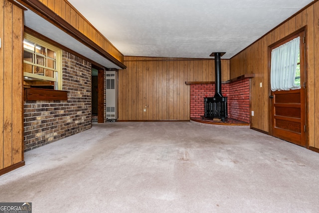3549 Dogwood Dr, Powder Springs, GA 30127 - unfurnished living room featuring a wood stove, wooden walls, carpet floors, a textured ceiling, and baseboards